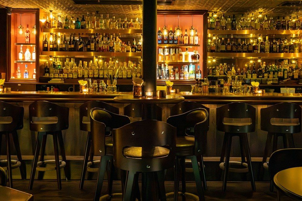 Dimly lit speakeasy bar with counter stools